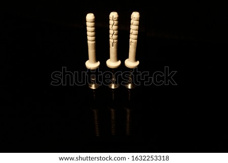 Three wall dowel pin with screw isolated on black with reflections