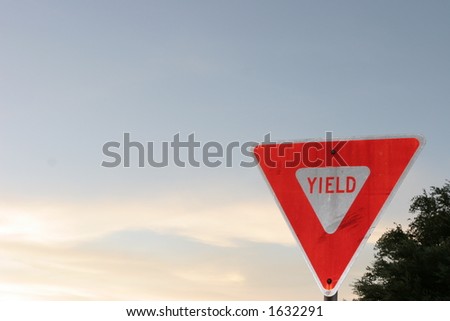 Yield sign at lower right corner with open sky