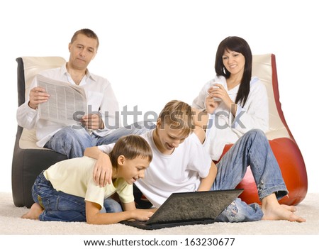 Friendly family resting with laptop on the floor