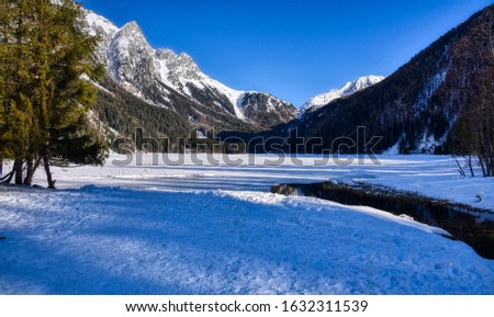 The frozen surface of Lake Anterselva nestled in the mountains Royalty-Free Stock Photo #1632311539