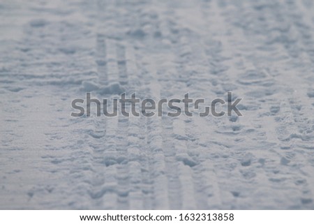 Rribbed footprint in snow left snowcat. Preparation of ski slopes. The concept of snow removal, ski resorts, active winter vacations. Stock photo with empty space for text