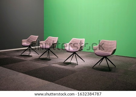 Four empty chairs in a studio with green screen Royalty-Free Stock Photo #1632384787