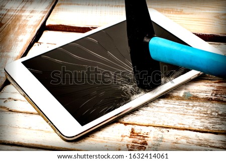 Background with a hammer breaking a tablet screen.