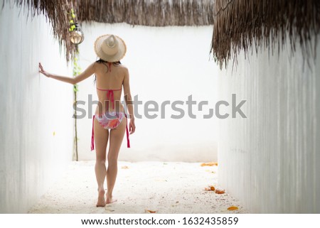 Woman wearing bikini relaxing at beach resort