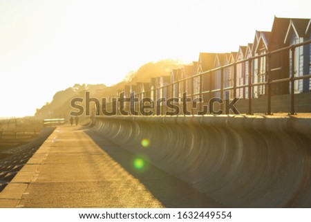 Felixstowe Beach Huts with warm bright sunny background and lens flare. Royalty-Free Stock Photo #1632449554