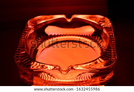 a glass ash tray in orange light