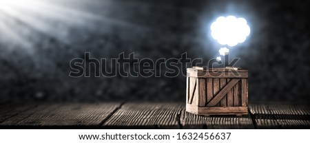 "Think Outside The Box" Concept - Old Wooden Box On Table With Bright Glowing Thought Cloud Above