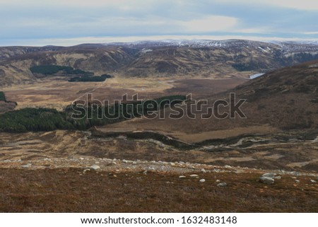 A wide angle landscape image showing Glen Muick from the upper slopes of Conachcraig in the Scottish Highlands.  Loch Muick can just be seen to the right of picture.