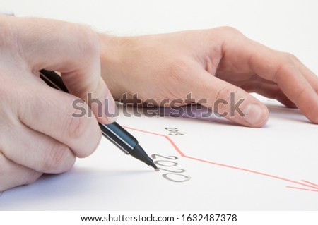 Hands of a male businessman write on a white sheet a growth graph. Growth arrow in 2020. On a white background.