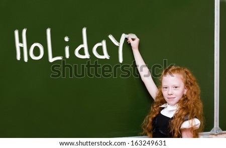girl writes the word "holiday"