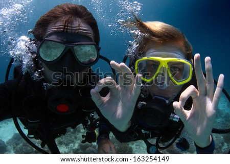 Scuba divers showing OK signal underwater