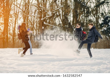four young friends are walking in the winter snow-covered forest