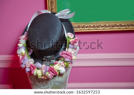 Pink and red Flower on black hat . pink background
