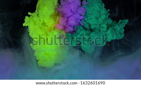 Multicolored composition from ink streams. ink streams from the rainbow spectrum float and mix in the center of the composition. Colorful abstract combination of acrylic rainbow colored black