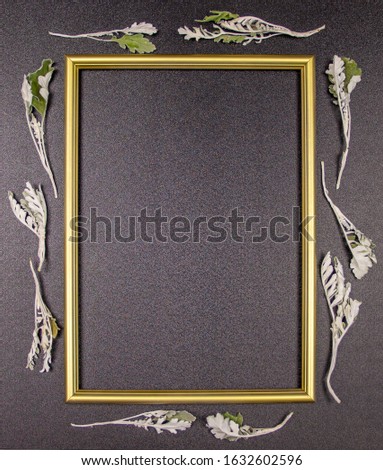 composition, golden photo frame on a gray background with leaves. Flat lay, top view, copy space.