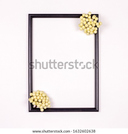composition, black photo frame on a white background with white beads. Flat lay, top view, copy space.