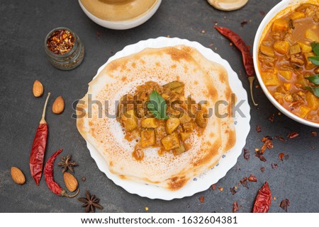 Appam, Kallappam, Vellappam, meat, mutton curry, beef Kaya Masala, hot and spicy christian Kerala breakfast on dark black background. fermented rice pan cake. Top view Indian non vegetarian food 