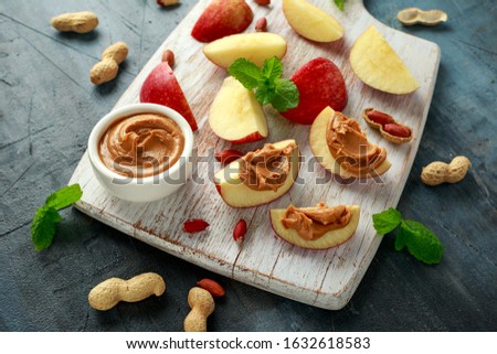 Peanut butter and apple to snack. on white wooden board