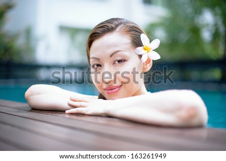 Attractive Asian Woman in Pool deck resting
