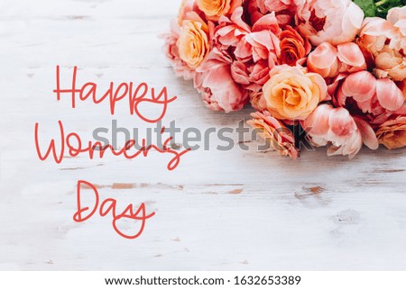 Happy Women's Day words. Fresh bunch of pink peonies and roses on wooden rustic background. Card Concept, pastel colors, close up image, copy space