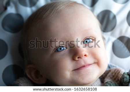 Portrait Of A Beautiful Baby Boy With Blond Hair And Blue Eyes