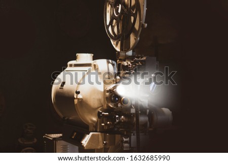 Vintage movie, cinema and movie reel projector on dark background. Royalty-Free Stock Photo #1632685990