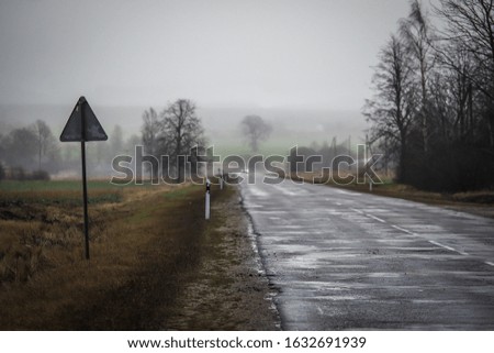 Asphalt highway in early spring with fog and car in the background, defocused