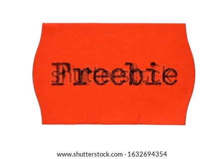 Freebie word printed with typewriter font on red price tag sticker isolated on white background