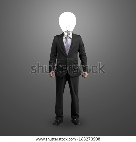businessman with lighting bulb head standing and isolated in dark gray background