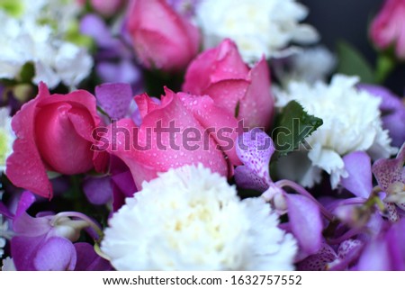 A close uprose and picture of a bouquet of flowers  That has many kinds of flowers