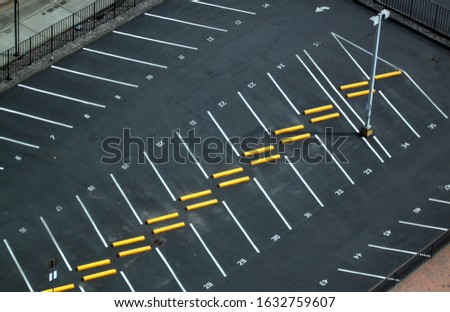 Abstract aerial shots of parking lot with white and yellow stripes and signs
