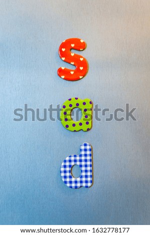 A Vertical shot of colorful words spelling out sad
