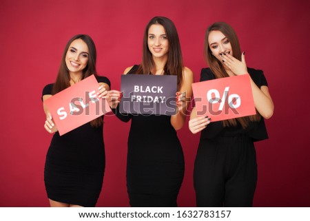 Elegant brunette women wears black dress holding shopping bags, black friday concept.