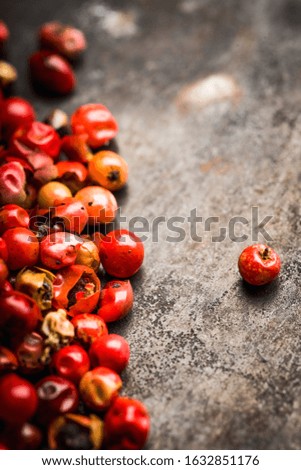 Red peppercorns on the rustic background. Selective focus. Shallow depth of field.
