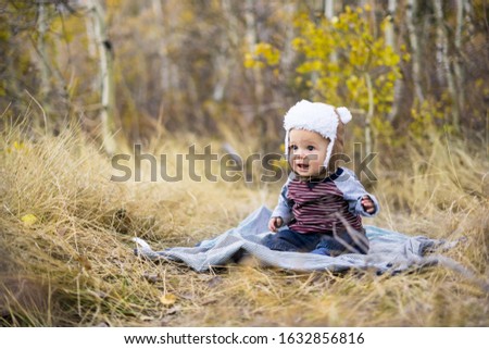 Little boy poses for pictures on blanket in tall wheat grass
