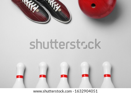 Bowling ball, shoes and pins on white background, flat lay
