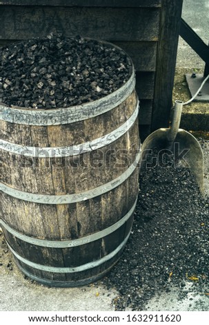 Charcoal in a Barrel and a Shovel, used for Mellowing Tennessee Whiskey by Filtration Royalty-Free Stock Photo #1632911620