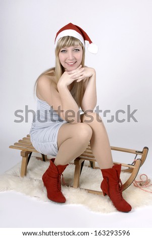 Beautiful fair haired young woman sitting on a sleigh