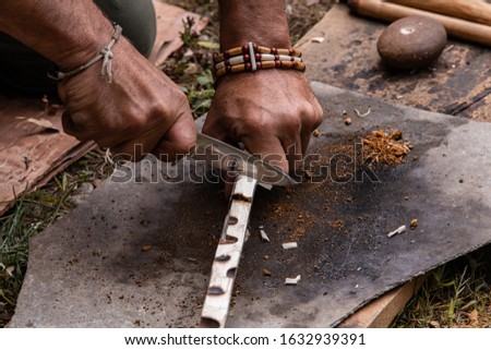 Closeup image of cropped hands man demonstrating a native traditional method for natural fire lighting during world and word festival