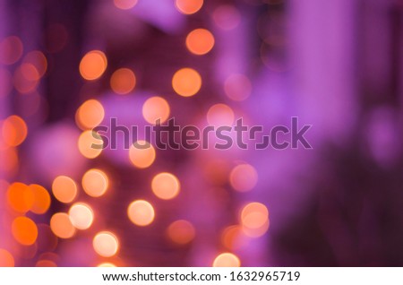 Abstract festive background with bokeh defocused lights. Blurred Bokeh background in orange and purple