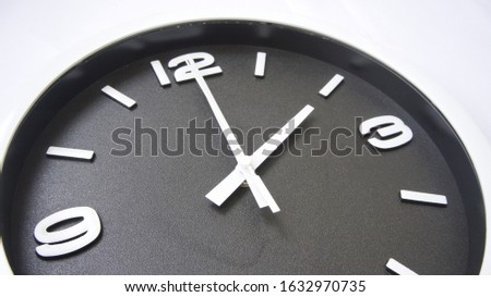 Image of a black faced clock showing two o'clock