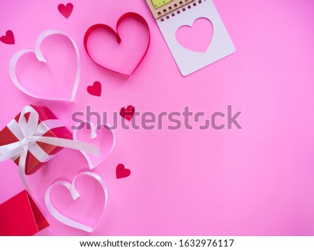 flat lay of valentine concept, ribbon shaped heart and gift box on pink pastel background with blank space for text.