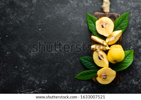 Fresh quince fruits on a wooden board. Top view. Free space for text.