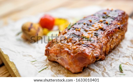 grilled meat ribs with vegetables on wooden table