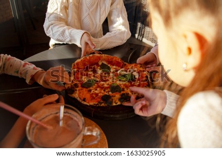 Top view image of children hands grab slice pizza. Group of kids eating italian food in in cafe. Hungry children holding appetite piece of tasty pizza. People celebrating birthday in pizzeria.