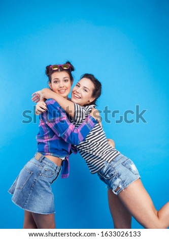 lifestyle people concept: two pretty young school teenage girls having fun happy smiling on blue background