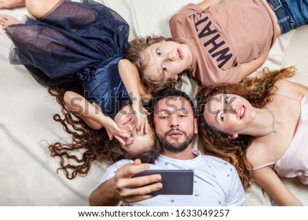 Happy family taking selfie picture with smartphone at home, mother, father, son and daughter, holidays, technology and people concept