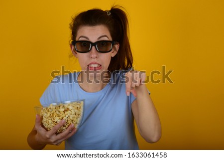 young woman in t-shirt with popcorn at the cinema