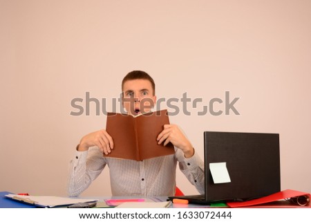 a man in a shirt sits in an office with business documents