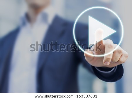 Businessman pressing play button to start or initiate projects Royalty-Free Stock Photo #163307801